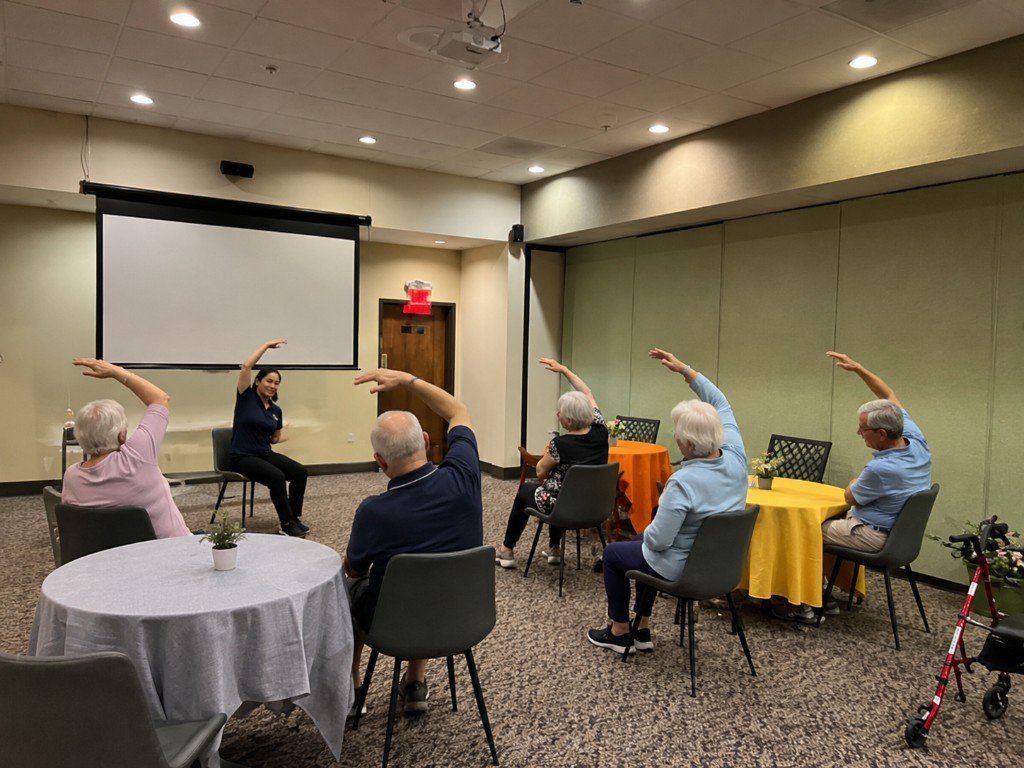 Residents participating in a guided exercise and wellness class